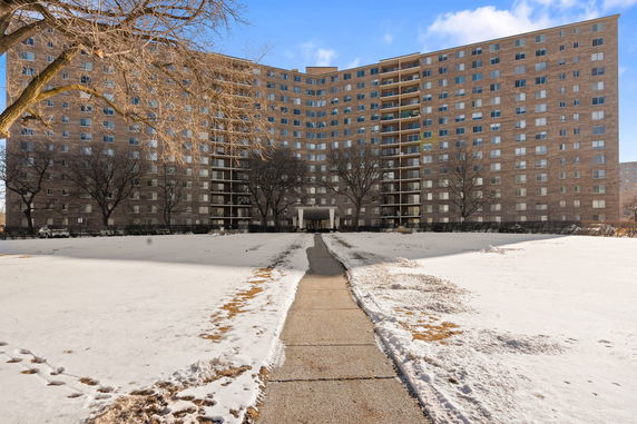 Front view of a multi-story apartment building with numerous windows and balconies.