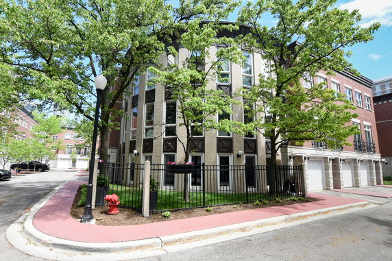 Front view of a multi-story residential building with large windows and garage doors.