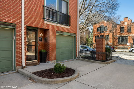 Front view of a brick house with a garage and entryway.