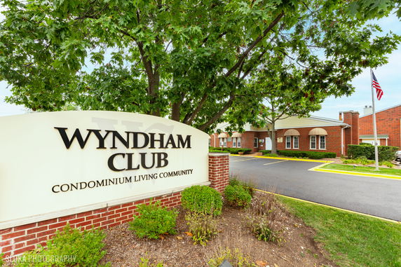 Front view of a brick building with a sign for Wyndham Club Condominium Living Community.