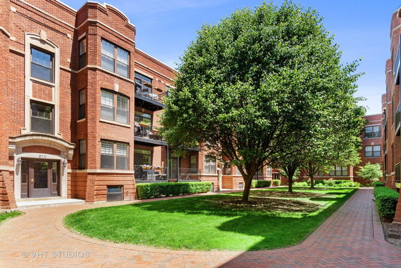 Front view of a multi-story brick apartment building with balconies.
