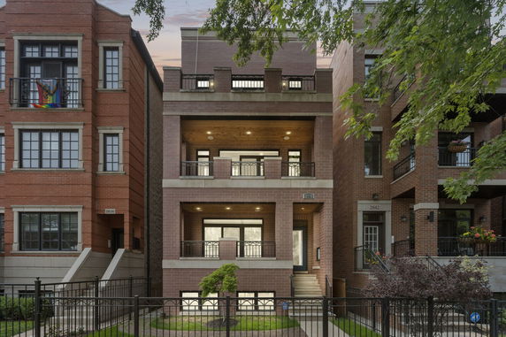 Front view of a multi-story brick building with balconies.