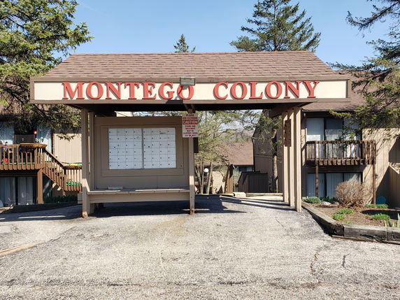Front view of a building entrance with a sign reading MONTEGO COLONY.