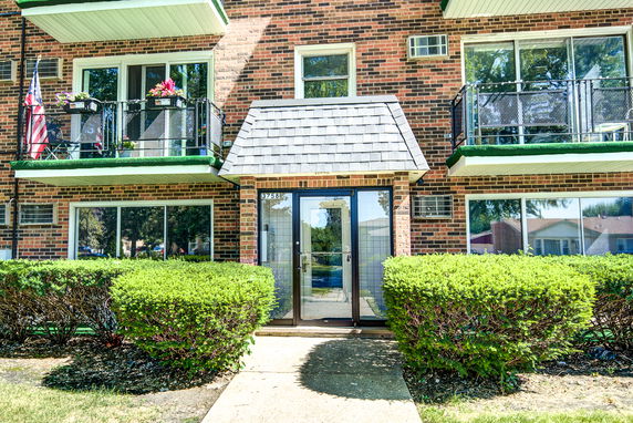 Front view of a building with balconies and a central glass entrance.