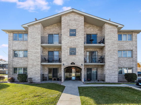 Front view of a three-story apartment building with balconies.
