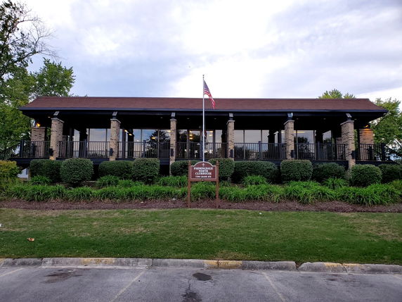 Front view of a building with columns and large windows.