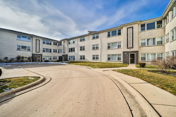 Front view of a multi-story apartment complex with a brick exterior.