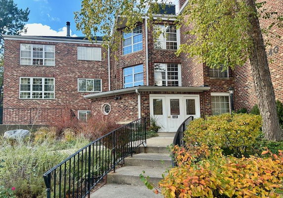Front view of a multi-story brick building with multiple windows.