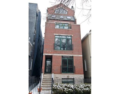 Front view of a multi-story brick house with greenery.