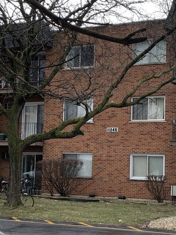 Front view of a multi-story brick apartment building.