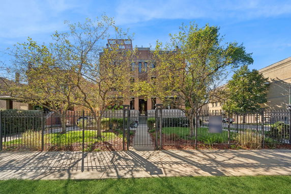 Front view of a two-story building with a gated entrance.