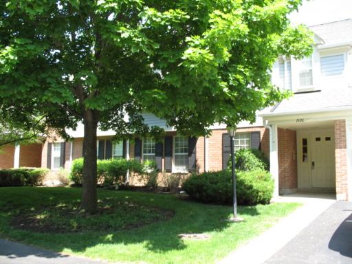 Front view of a two-story house with a brick facade.