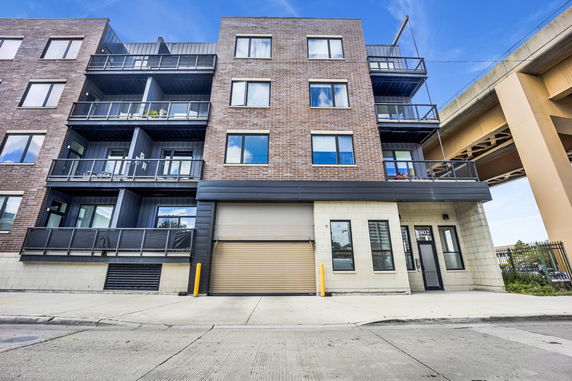 Front view of a multi-story apartment building with balconies.