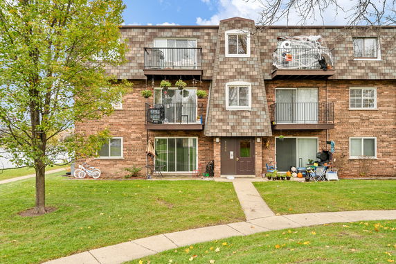 Front view of a multi-story brick building with balconies.