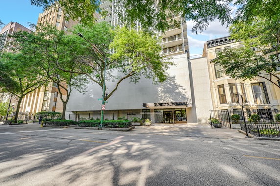 Front view of a multi-story residential building with a gated entrance.