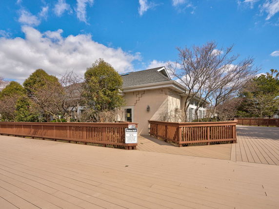 Front view of a single-story building with a wooden deck.