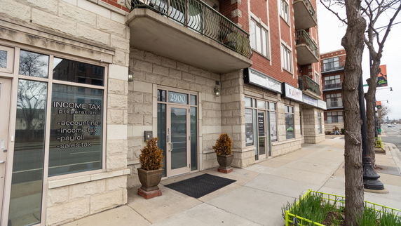 Front view of a building with multiple floors and business entrances on the street level.