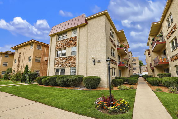 Front view of a multi-story apartment building with stone accents.