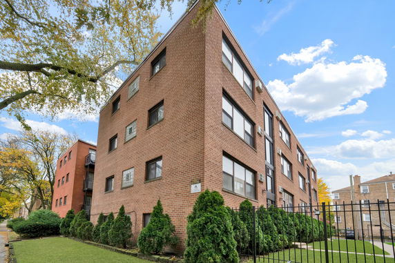 Corner view of a three-story brick apartment building.