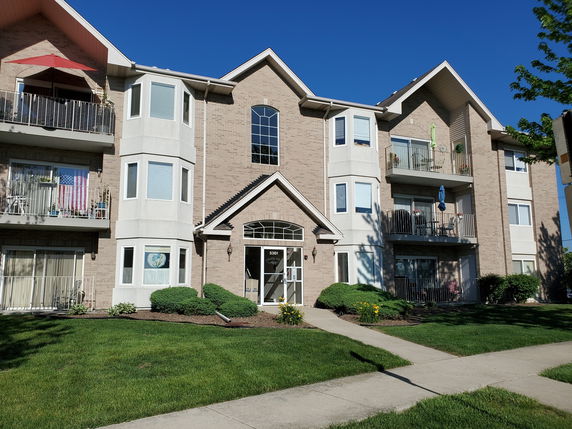 Front view of a multi-story apartment building with balconies.