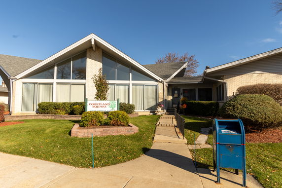 Front view of a house with large windows and a sloped roof.