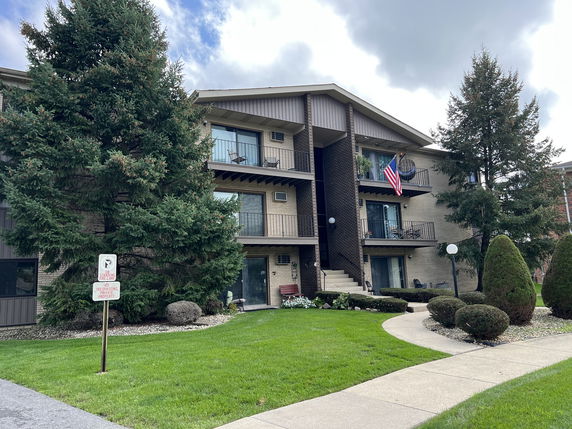 Front view of a multi-story apartment building with balconies.