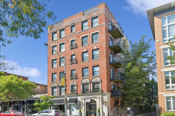 Front view of a multi-story brick building with balconies.