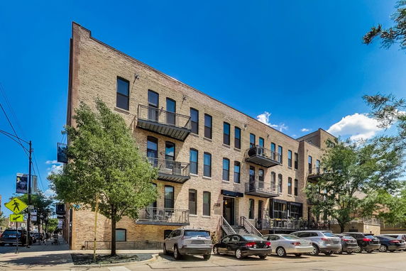 Front view of a multi-story brick building with balconies.