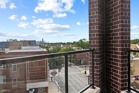 Panoramic view from a balcony showing city buildings and streets.