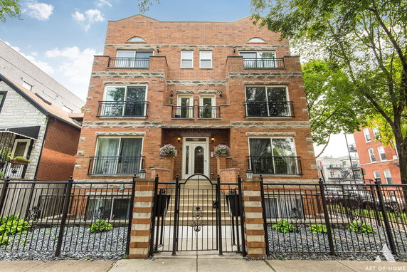 Front view of a multi-story brick building with balconies.