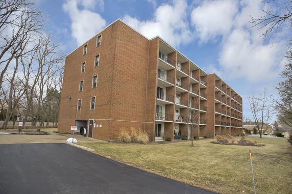 Front view of a multi-story brick building with balconies.