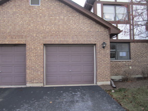 Front view of a house with a garage door and brick exterior.