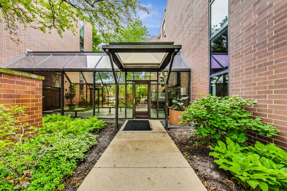 Front view of a building entrance with glass and brick elements.