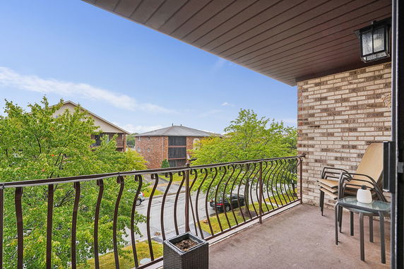 View from a balcony looking at neighboring buildings and trees.
