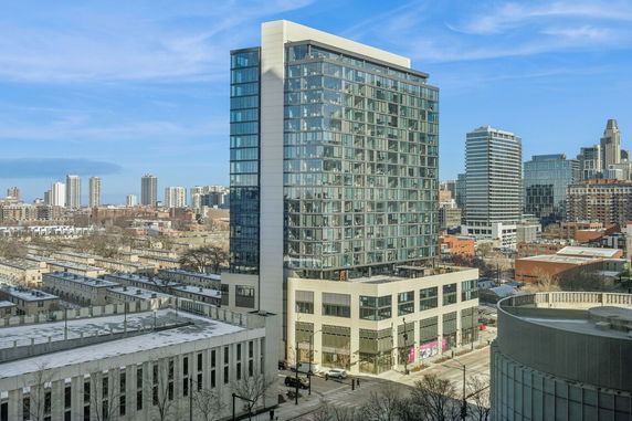 View of high-rise building in an urban area with multiple other buildings in the background.