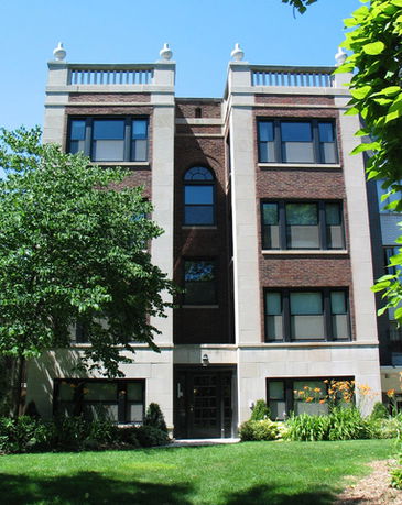 Front view of a three-story brick building with decorative stone elements.