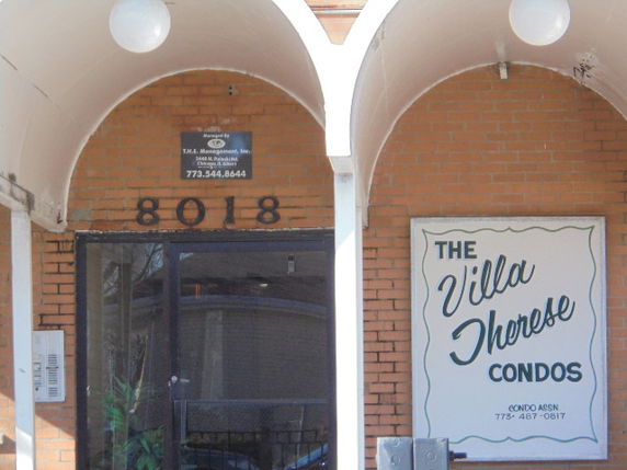 Front view of a brick condominium building entrance.