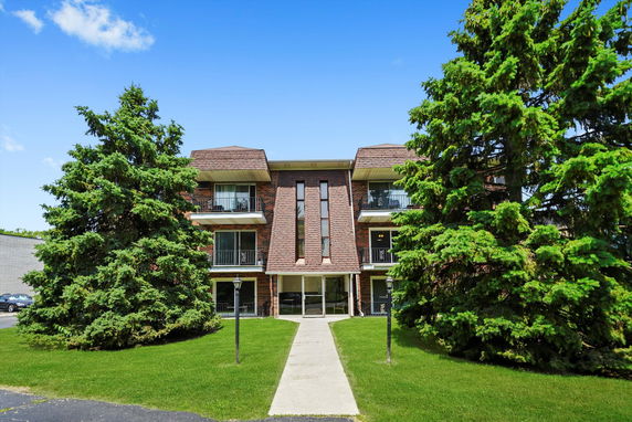 Front view of a brick apartment building with balconies.