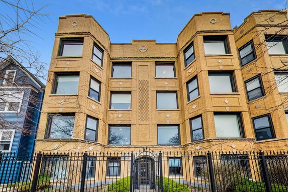 Front view of a multi-story brick building with multiple large windows.