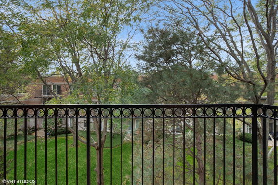 View from a balcony overlooking trees and a residential area.