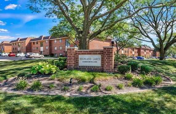 Front view of multiple condominiums with brick facade and landscaped surroundings.