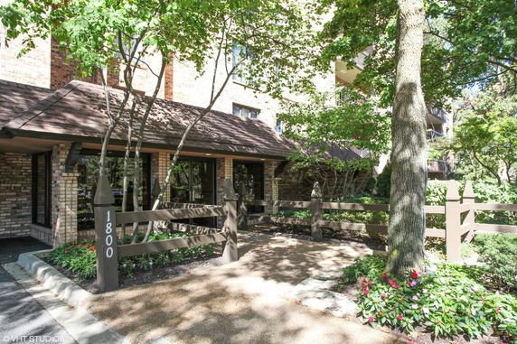 Front view of a building with a brick exterior and wooden fencing.