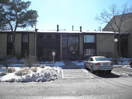 Front view of a two-story building with a parking area.