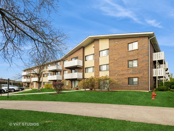 Front view of a multi-story residential building with balconies.
