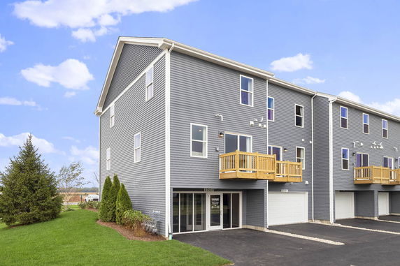 Front view of a multi-story building with attached garages and balconies.