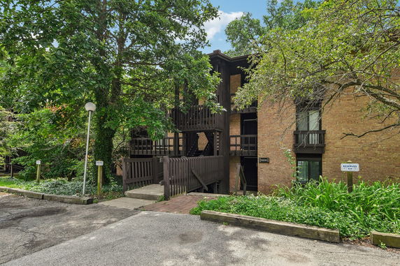 Front view of a multi-story building with wooden accents and a brick exterior.