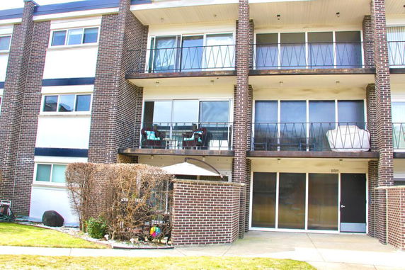 Front view of a multi-story building with balconies and brick facade.