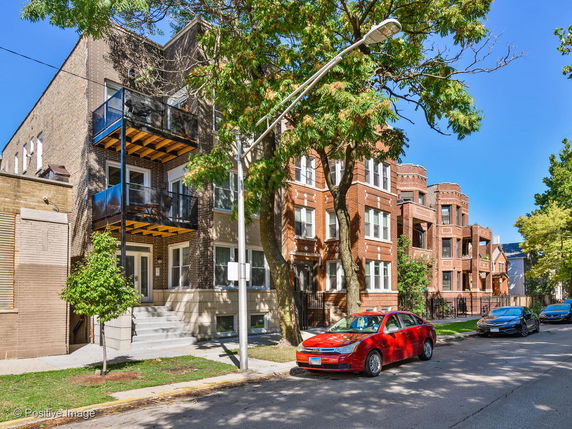 Front view of multi-story residential brick buildings with balconies.