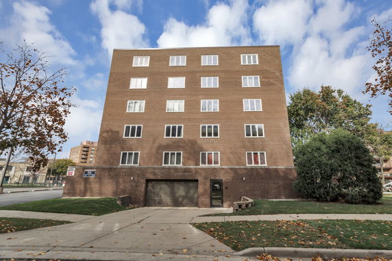 Front view of a multi-story brick building with multiple windows.