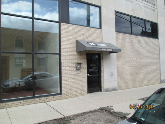 Front view of a commercial building with large windows and an entrance canopy.